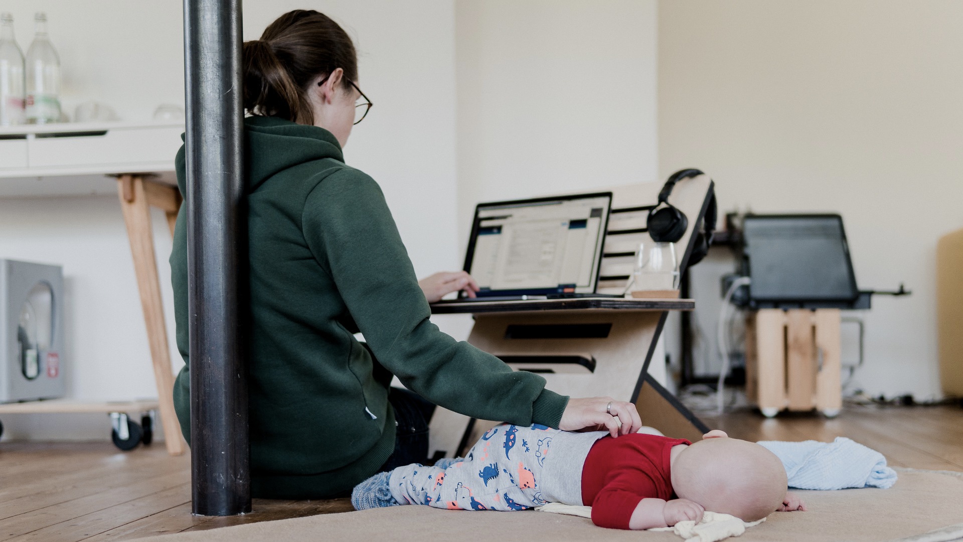 パソコン作業する女性と寝ている赤ちゃん