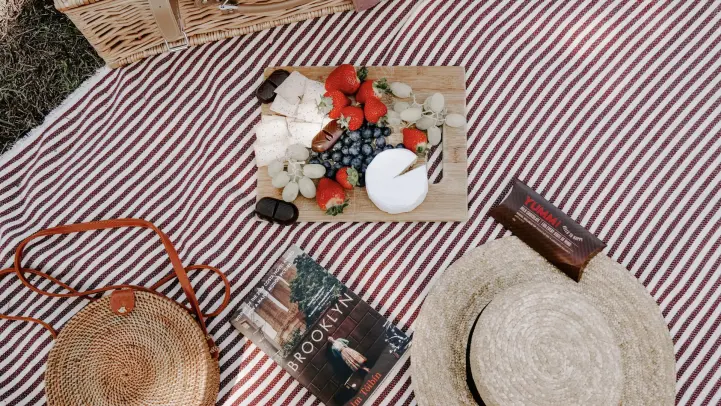 果物と帽子とかばんと本が置かれている画像