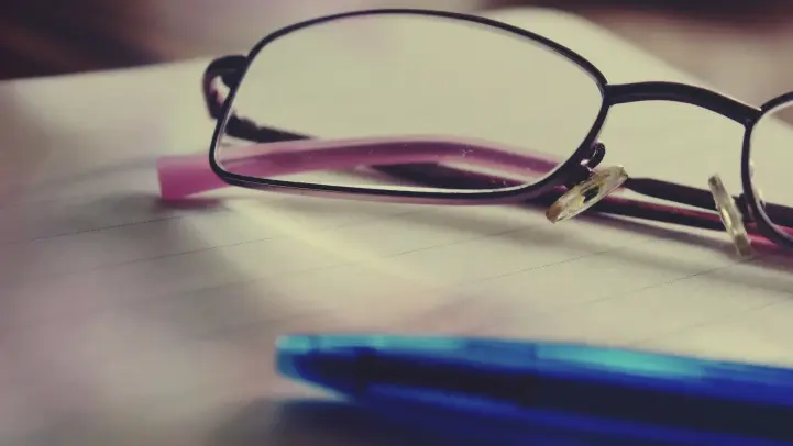 ノートの上のメガネとペン